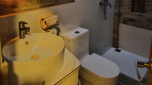 Stylish boutique-hotel bathroom with warm wooden elements and sleek modern fixtures.