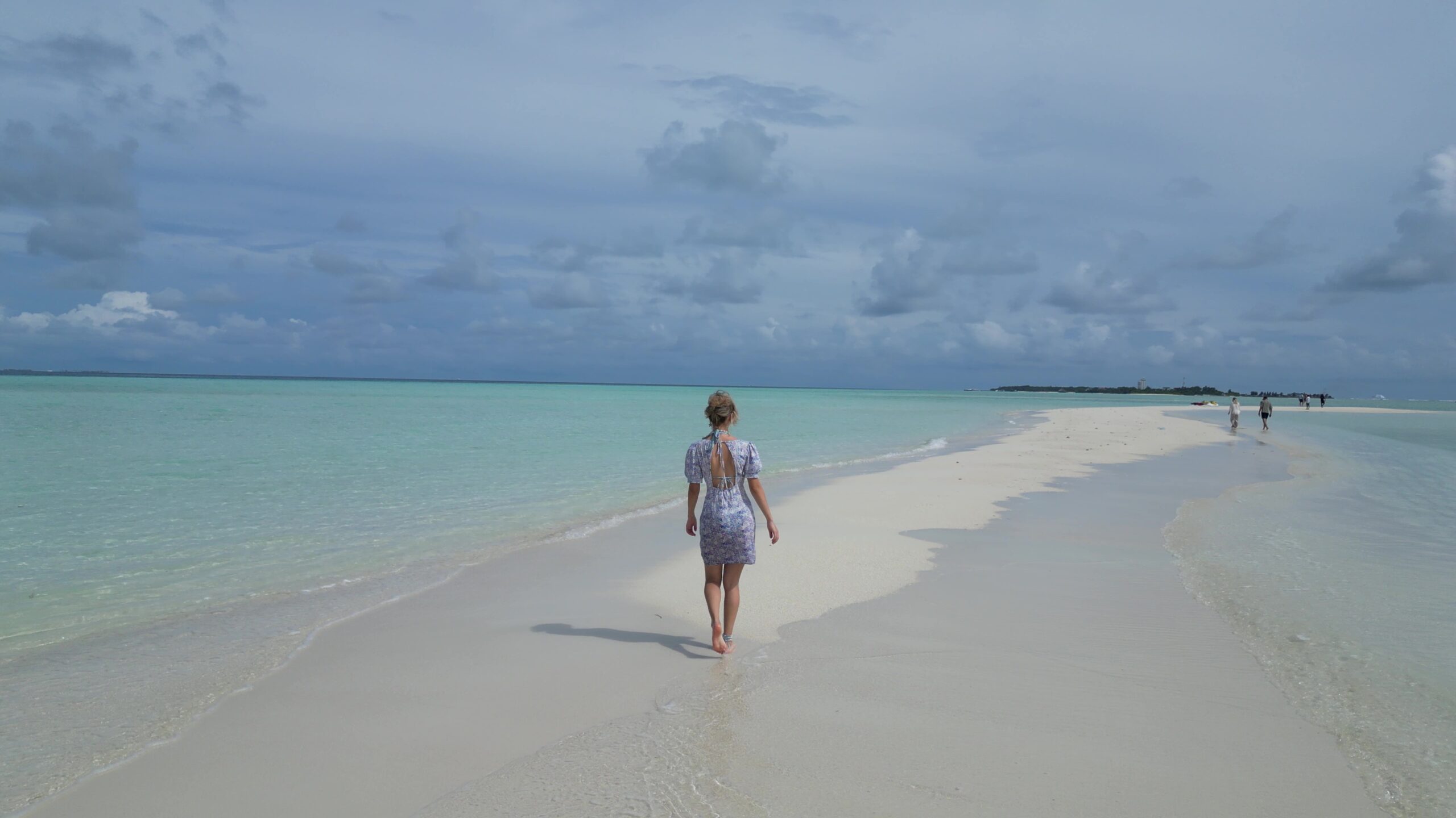 Peaceful Maldivian beach scene with oceanfront bungalows and warm sunset light.